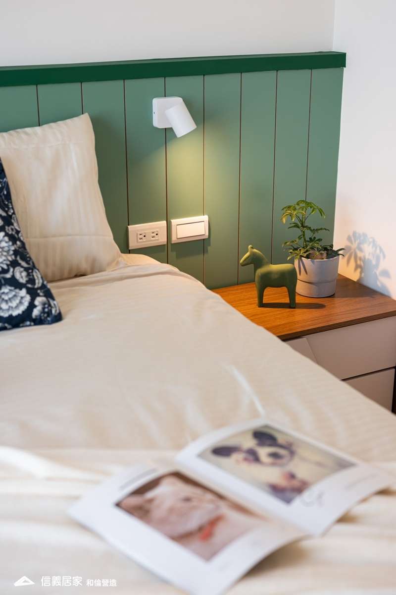 綠色臥室室內裝潢設計，包括床、床頭主牆、壁燈、床頭櫃裝潢圖片