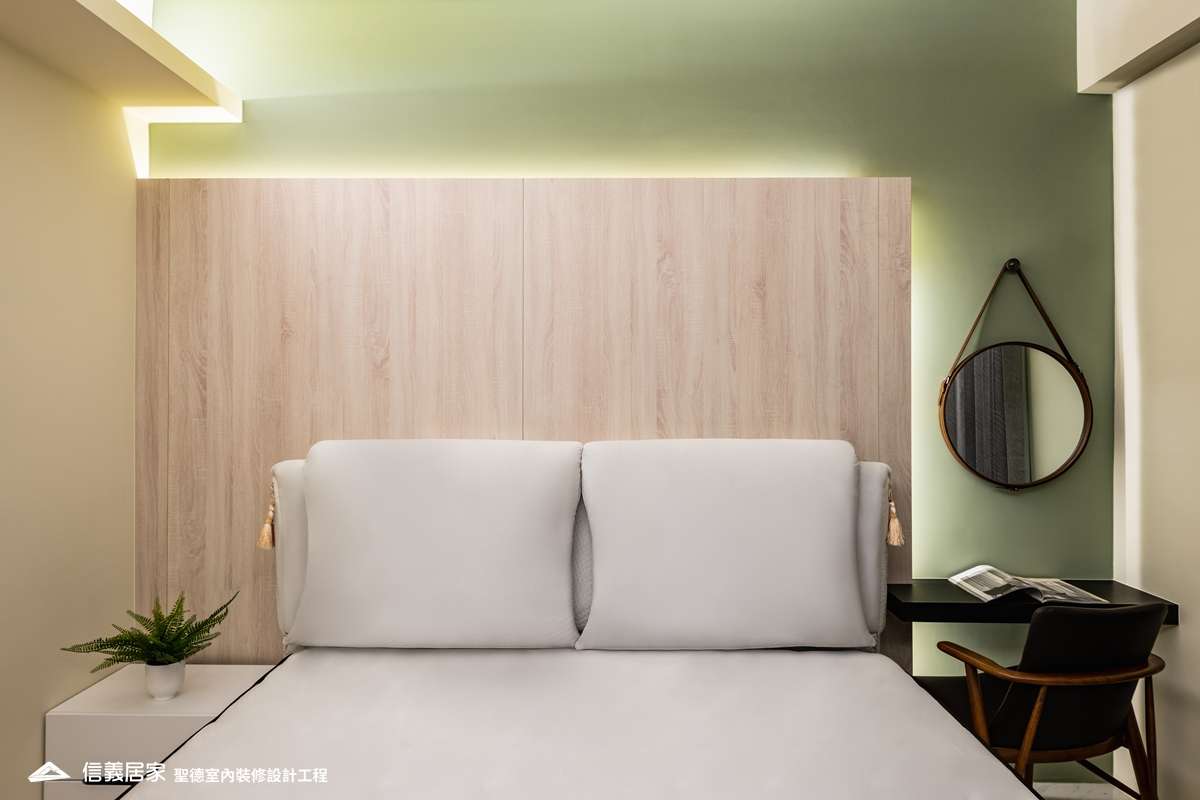 綠色臥室室內裝潢設計，包括床、椅子、鏡子、床頭主牆、床頭櫃裝潢圖片