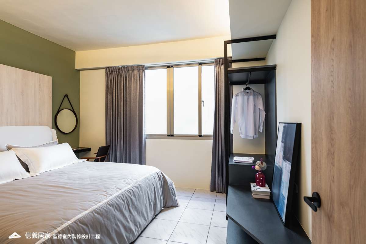 綠色臥室室內裝潢設計，包括床、椅子、鏡子、床頭主牆裝潢圖片